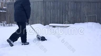 雪夜后工作.. 在一个寒冷的雪天早晨，一个拿着铲子把雪从院子里移走的人